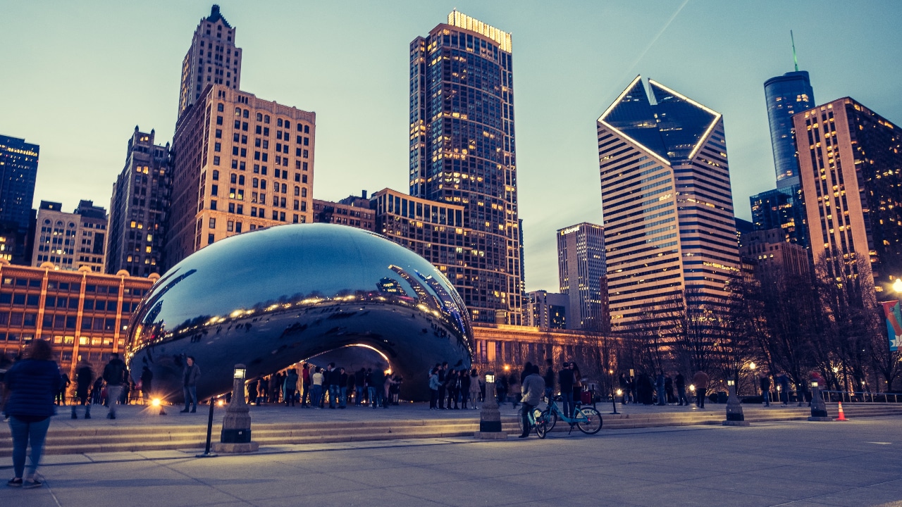 The Chicago skyline at dusk with the Cloud Gate sculpture in the background.