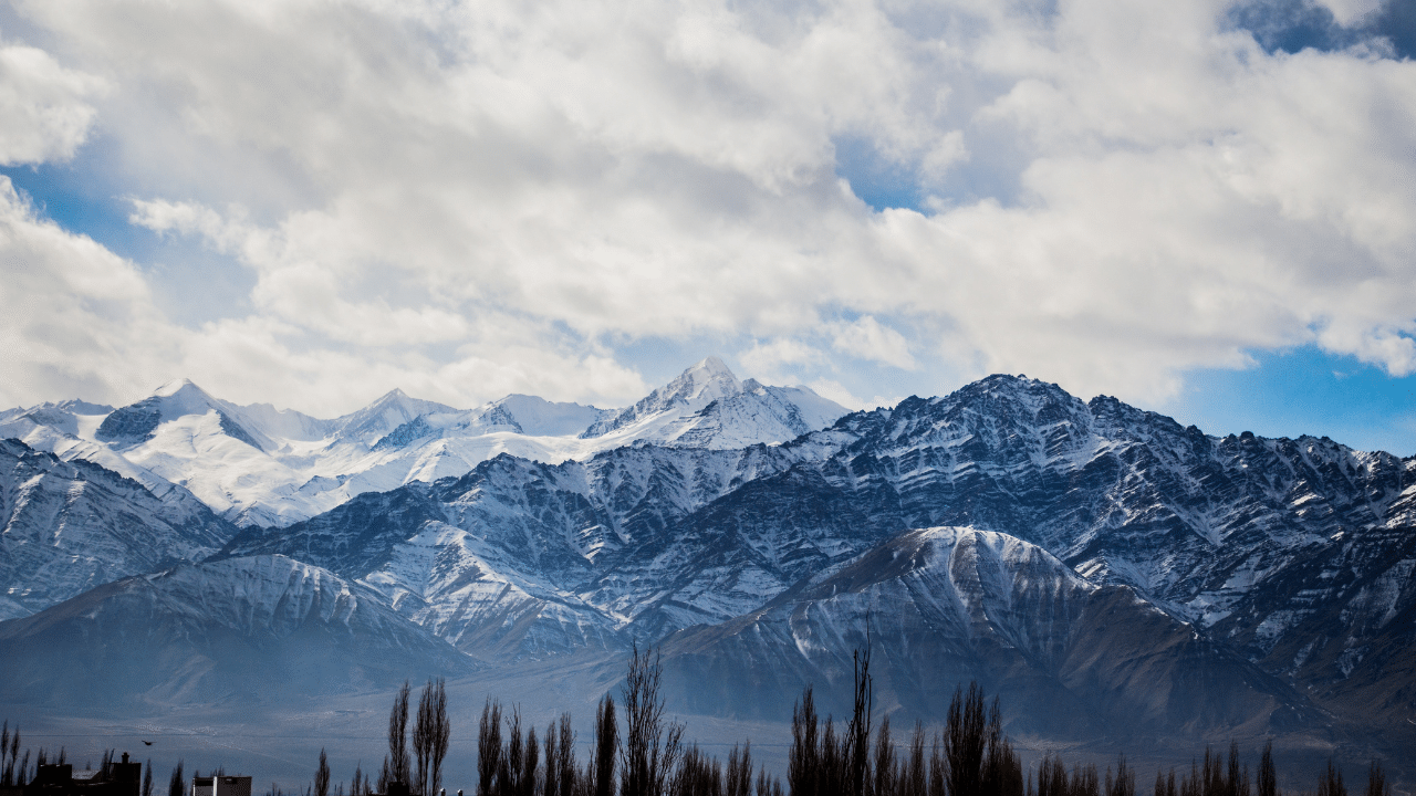 A snow covered mountain range with trees in the background, perfect for the Revel Rockies Marathon or Half Marathon.