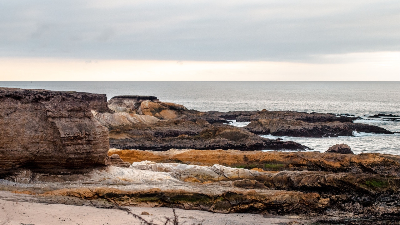 A rocky cliff overlooking the ocean on a cloudy day near San Luis Obispo.