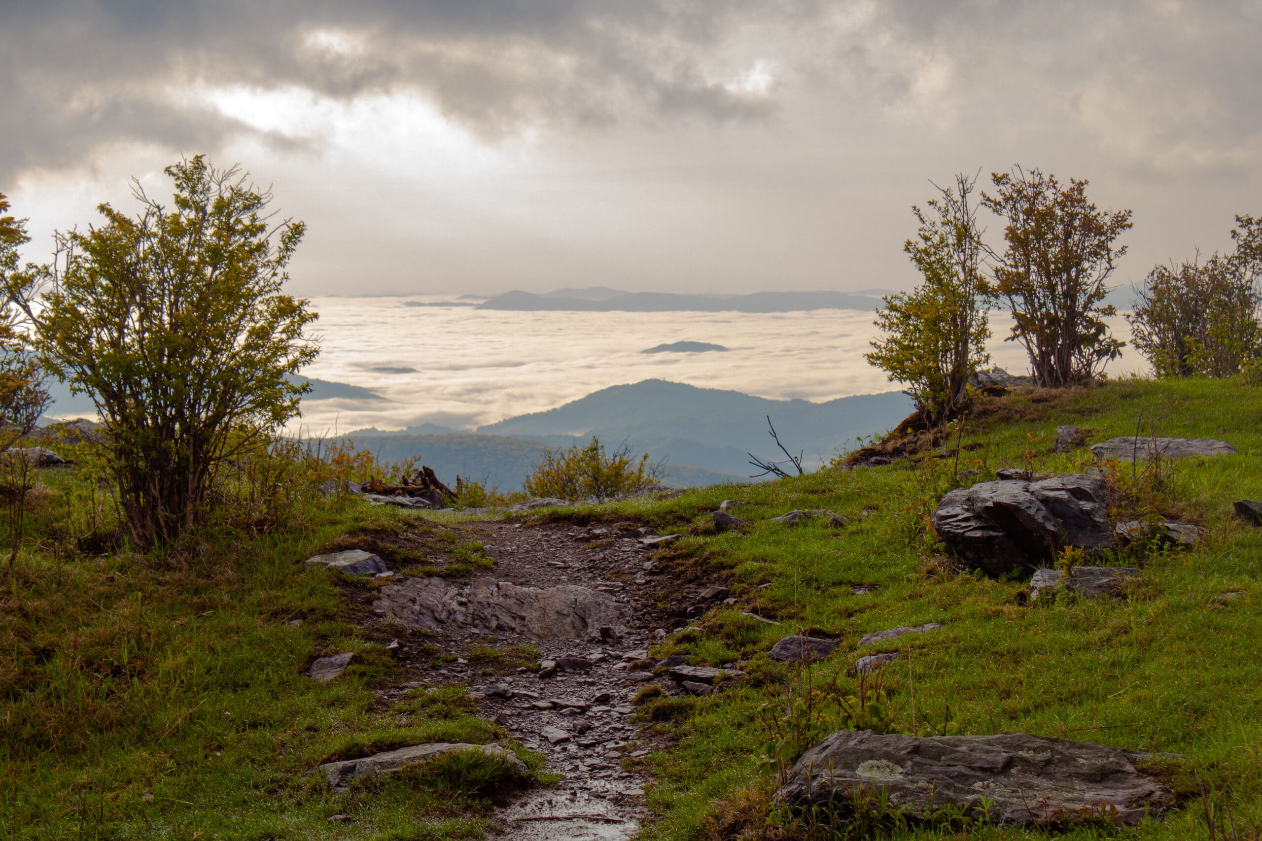 A cloudy sky over a grassy hill.