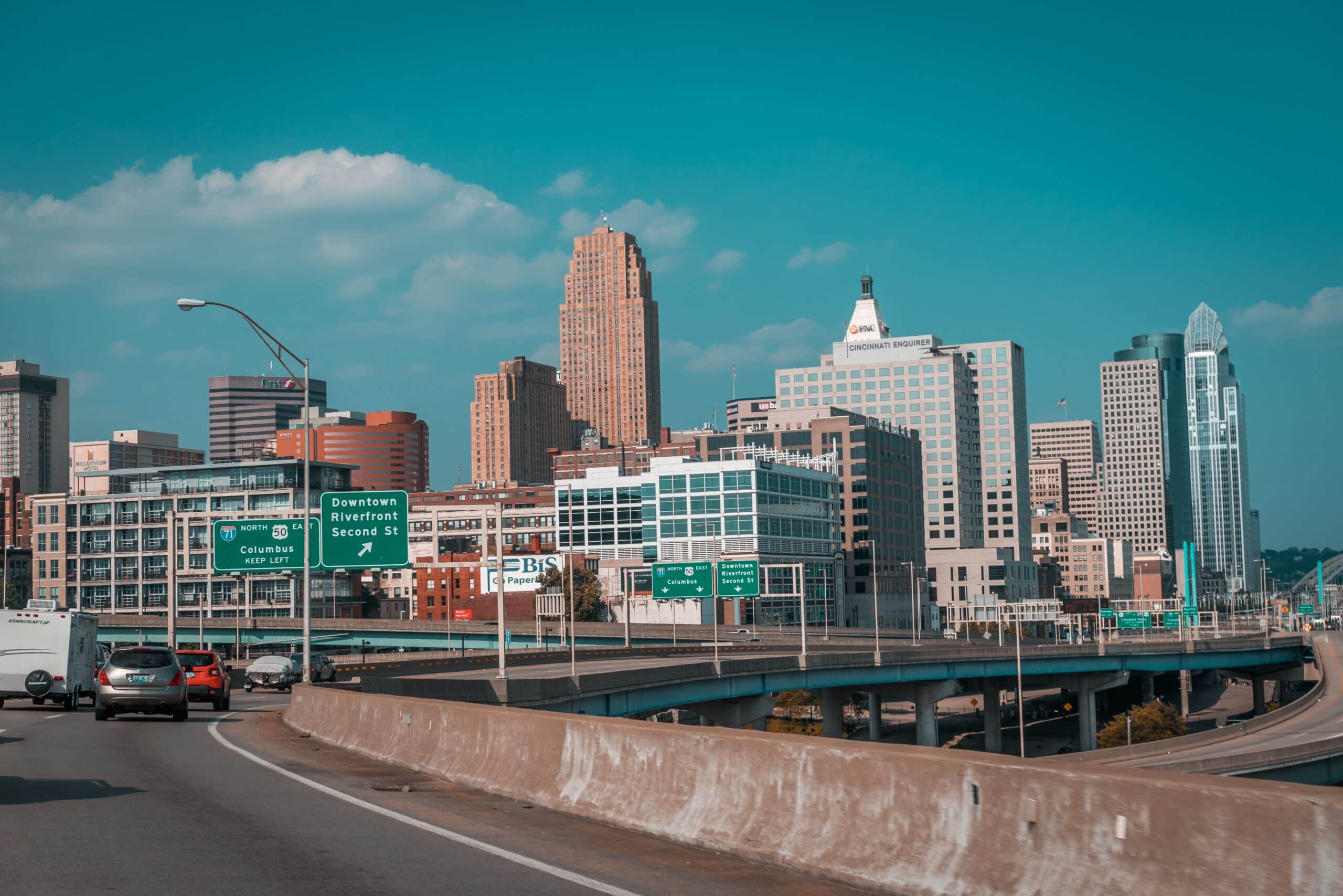 A city skyline with cars driving on a freeway.