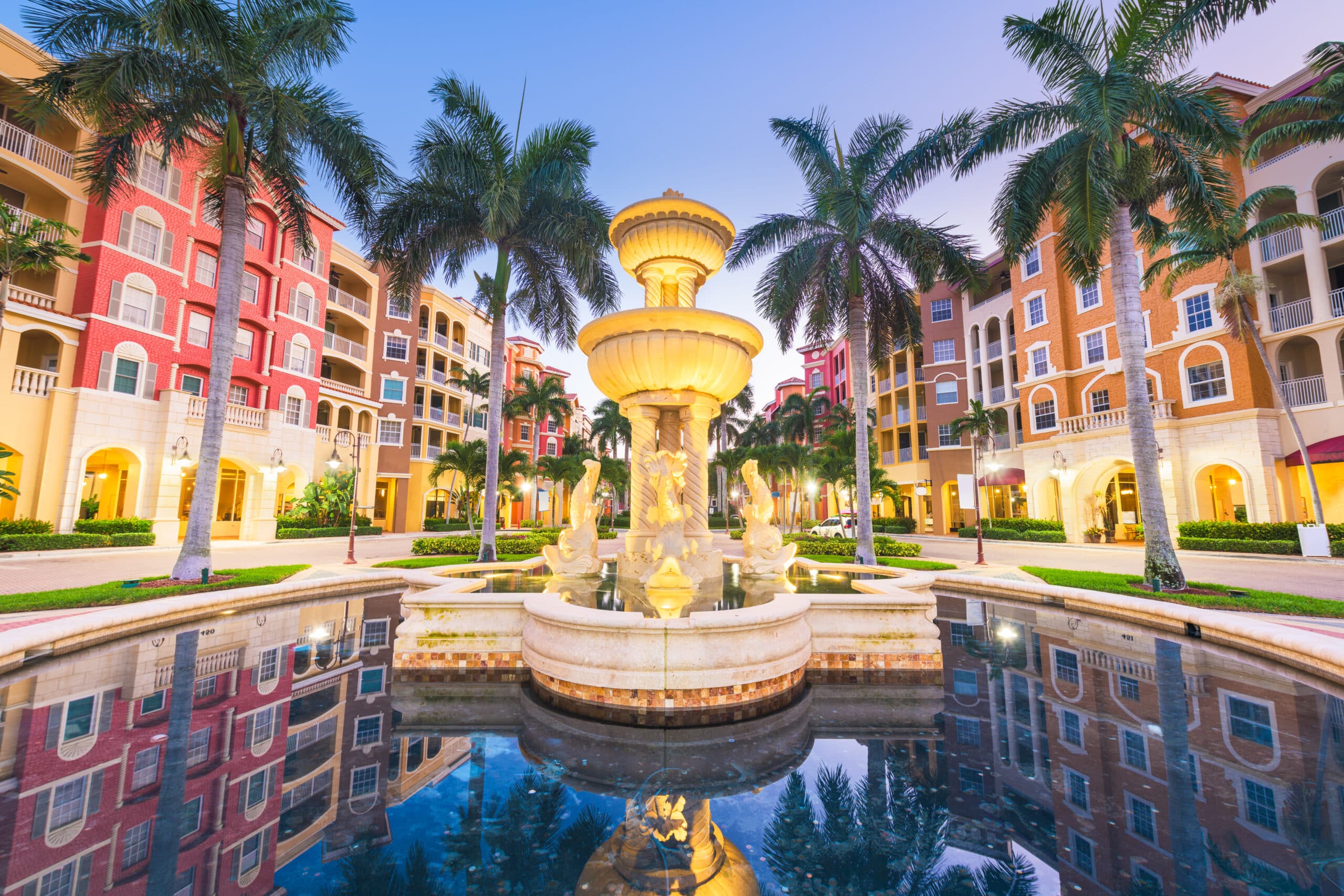 A fountain in the middle of a courtyard with palm trees.