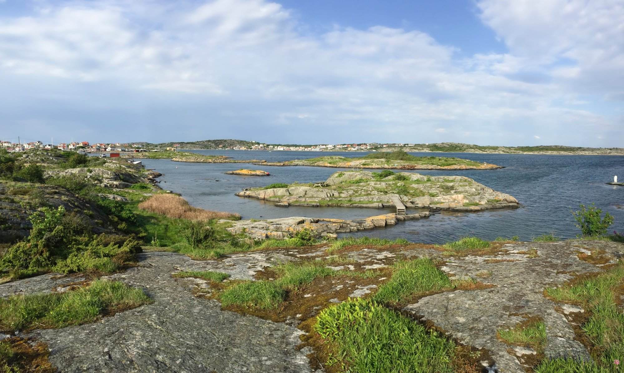 An Xperience of a rocky shore along the West Coast Trail with a boat in the water.