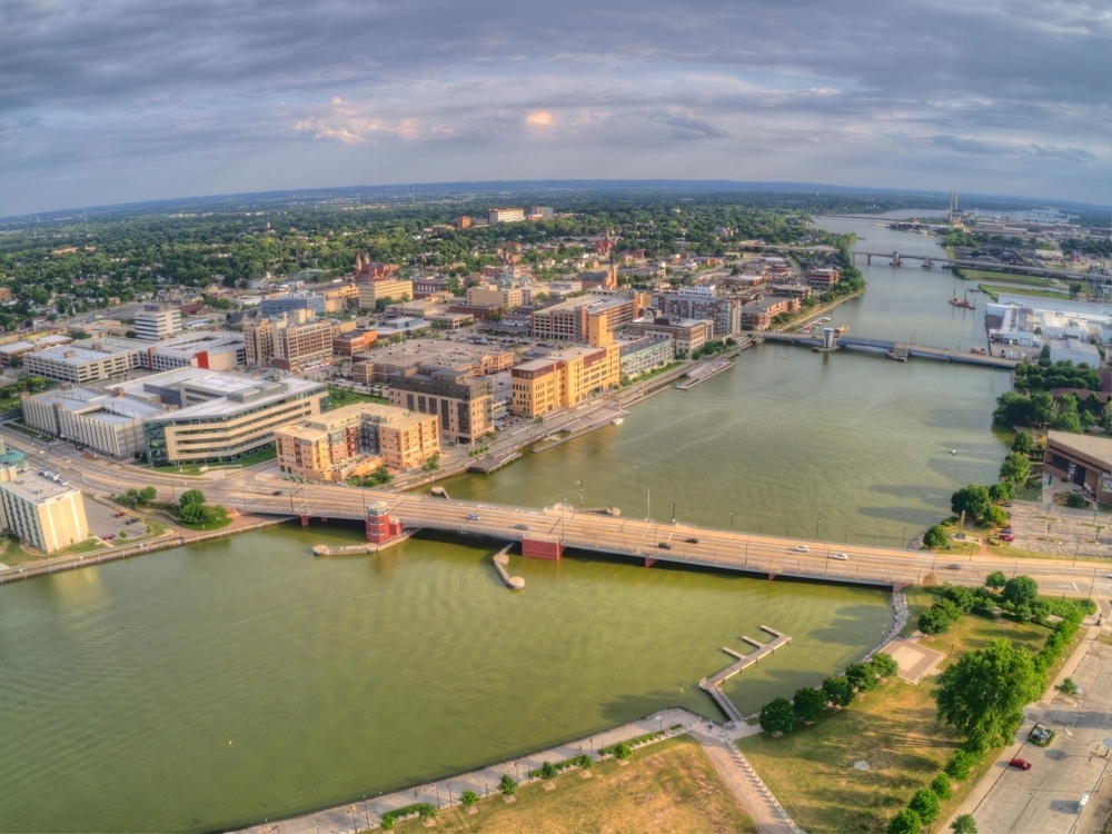 An aerial view of a city with a bridge over a river.