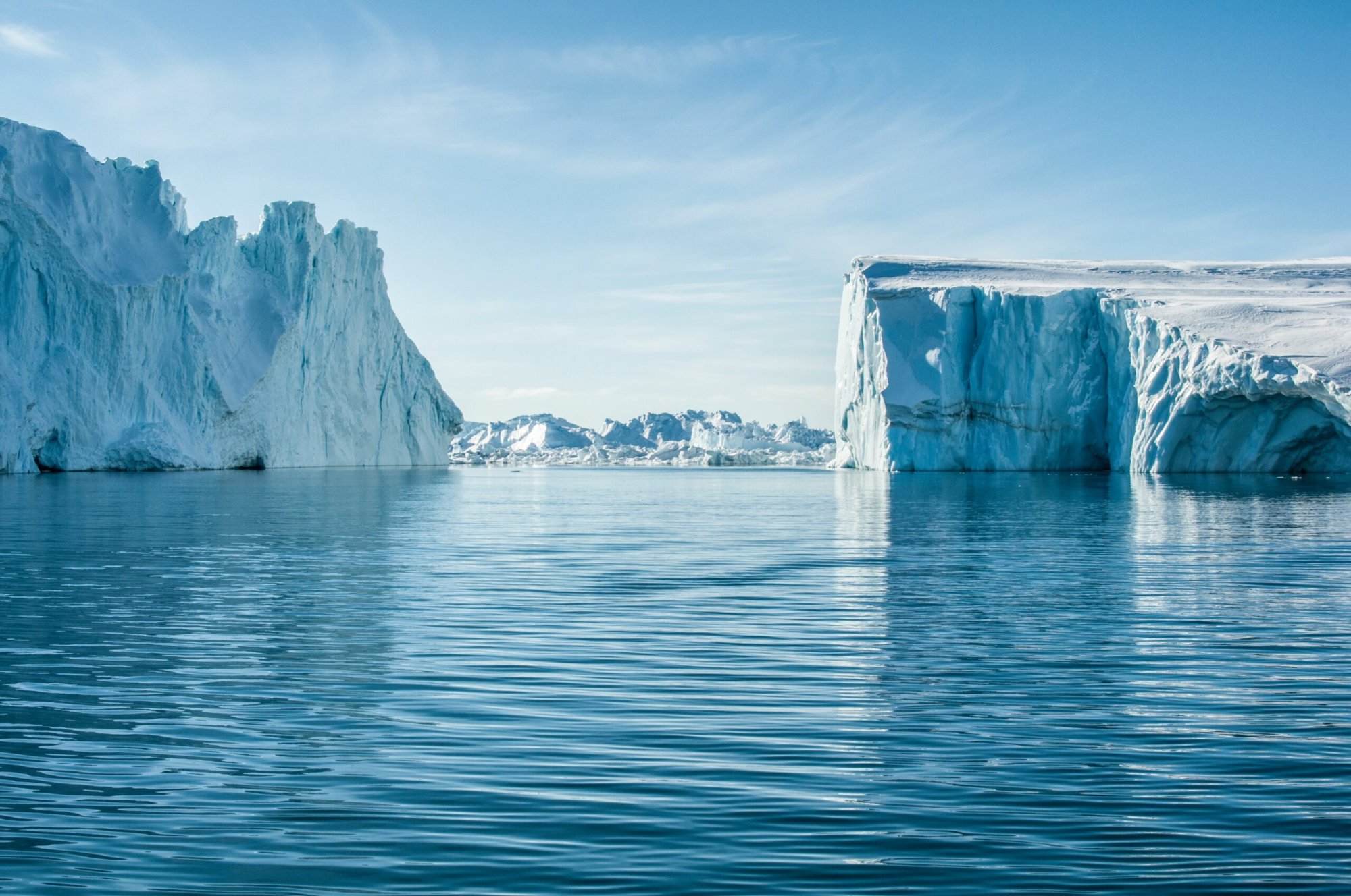 Icebergs floating in the water on a sunny day.