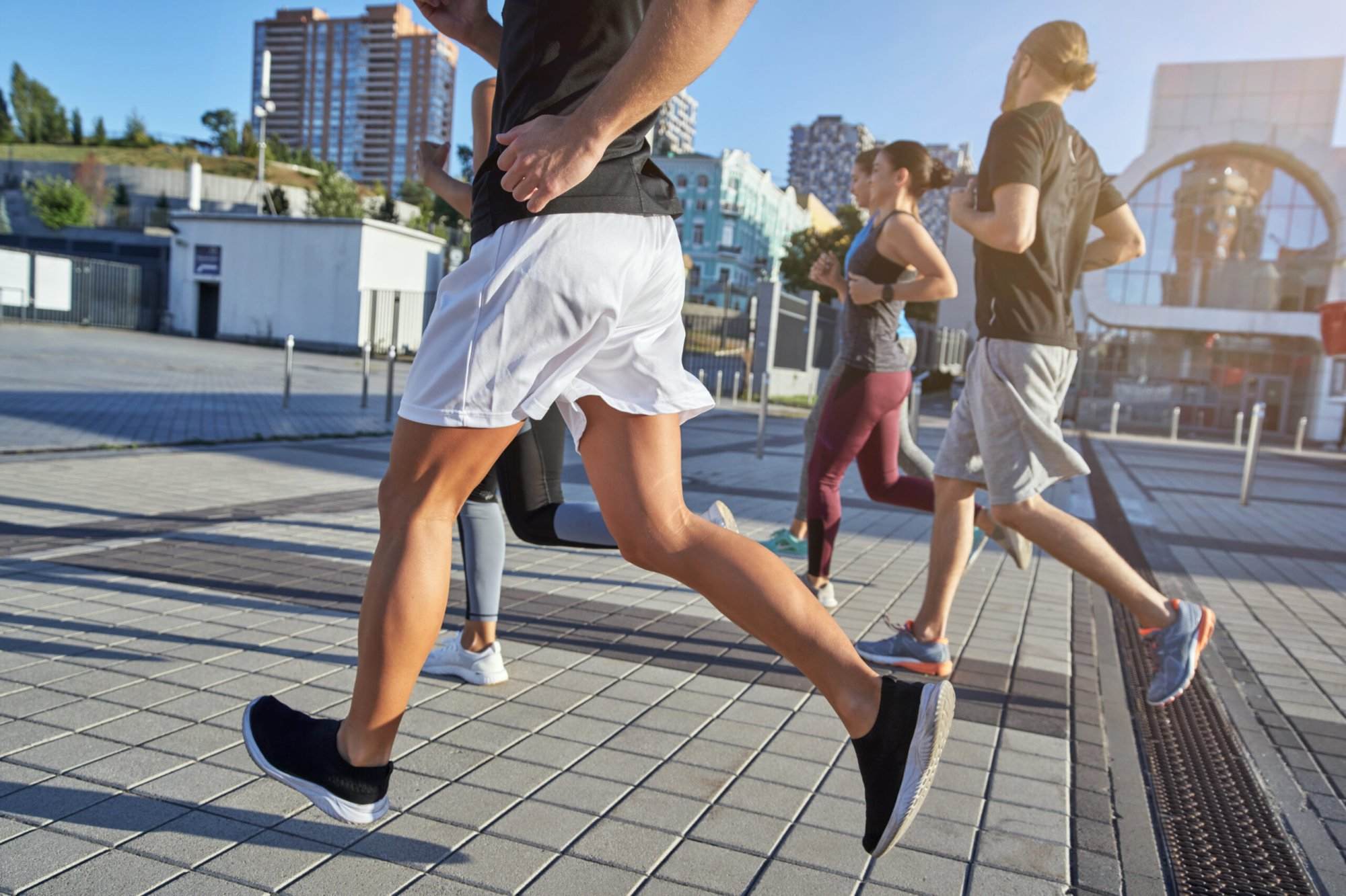 A group of people benefiting from running, jogging on a city street.