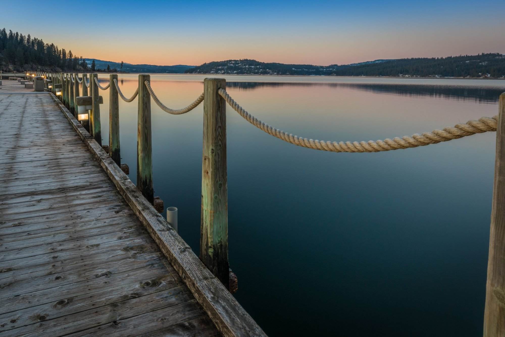 A pier leading to a lake at dusk.